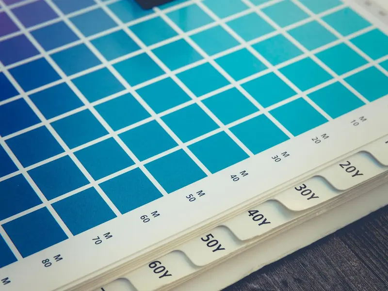 Printed colour swatch chart with a loupe, as used by print professionals